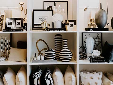 A shelf of nine equal-sized squares filled with various black and white items